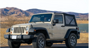 Two-door Jeep Wrangler with soft top in a desert mountain landscape, ready for open-air off-road driving. 