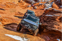 Ford Bronco tackling a rocky red rock trail in the desert Southwest, showcasing off-road capability for open-air adventure